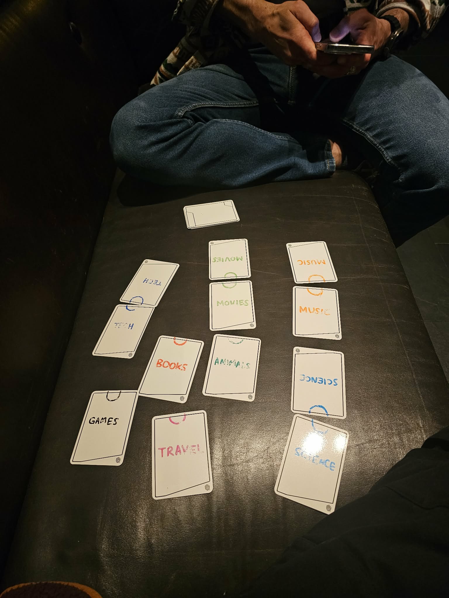 A late night playtest on a couch, cards laid out between two players