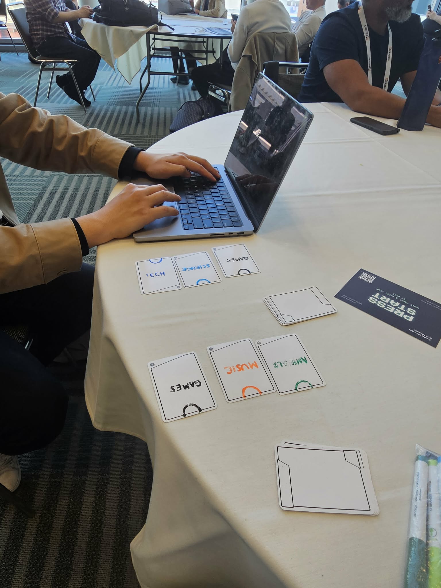 Two people playtesting the card game at a GDC table